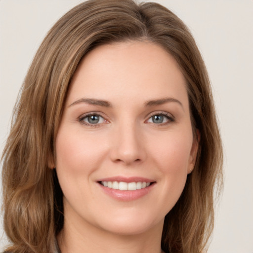 Joyful white young-adult female with long  brown hair and green eyes