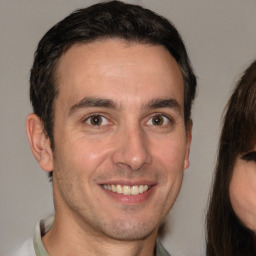 Joyful white adult male with short  brown hair and brown eyes