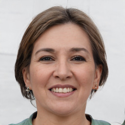 Joyful white adult female with medium  brown hair and grey eyes