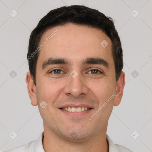 Joyful white young-adult male with short  black hair and brown eyes