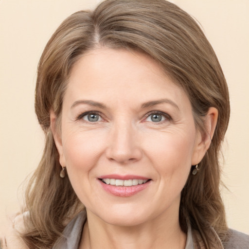 Joyful white adult female with medium  brown hair and grey eyes