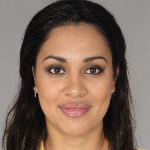 Joyful black young-adult female with long  brown hair and brown eyes