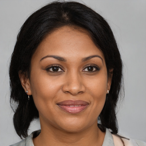 Joyful black young-adult female with medium  brown hair and brown eyes