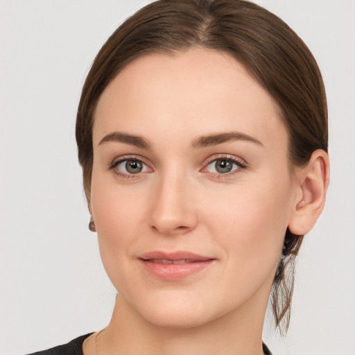 Joyful white young-adult female with medium  brown hair and grey eyes