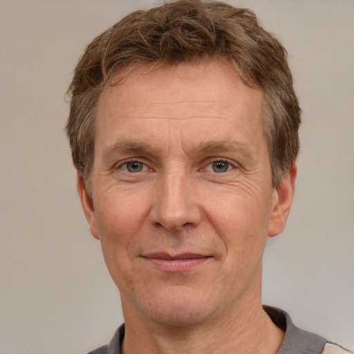 Joyful white adult male with short  brown hair and grey eyes