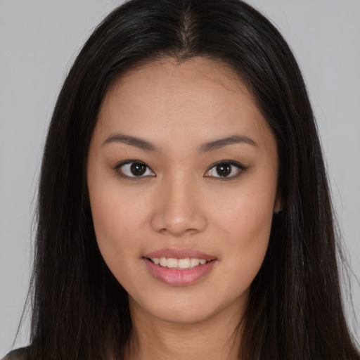 Joyful asian young-adult female with long  brown hair and brown eyes