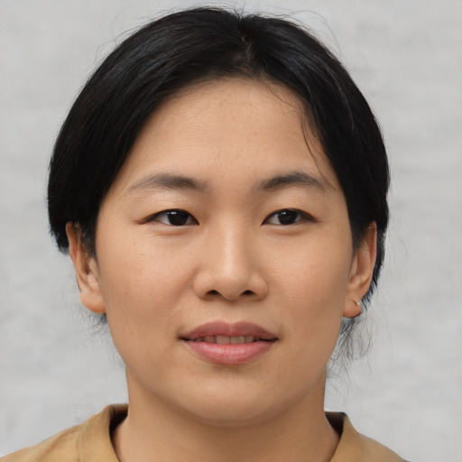 Joyful asian young-adult female with medium  black hair and brown eyes