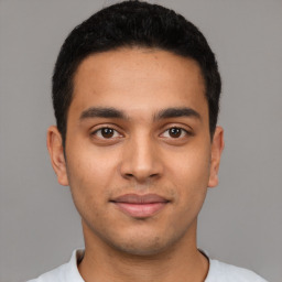 Joyful latino young-adult male with short  black hair and brown eyes