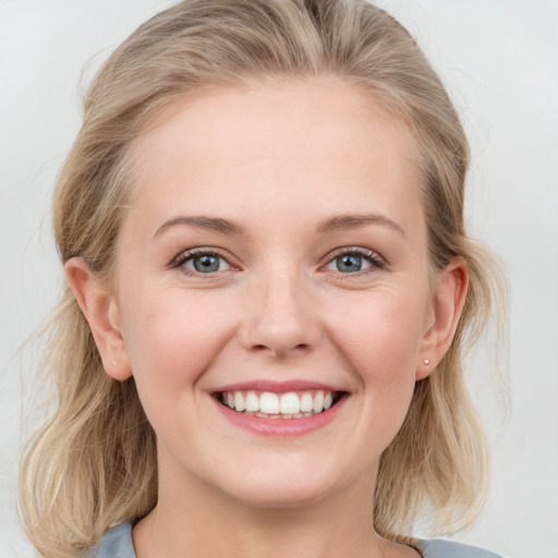 Joyful white young-adult female with medium  blond hair and blue eyes