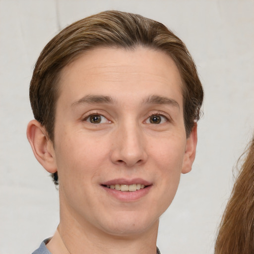 Joyful white young-adult male with short  brown hair and grey eyes