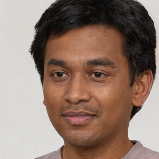 Joyful latino young-adult male with short  black hair and brown eyes