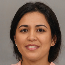 Joyful latino young-adult female with medium  brown hair and brown eyes