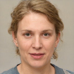 Joyful white adult female with medium  brown hair and blue eyes