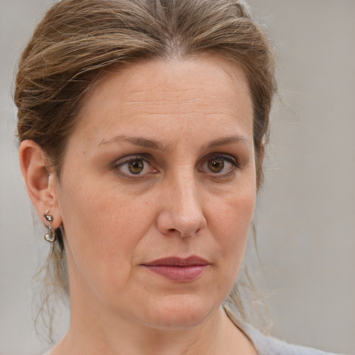 Joyful white adult female with medium  brown hair and grey eyes