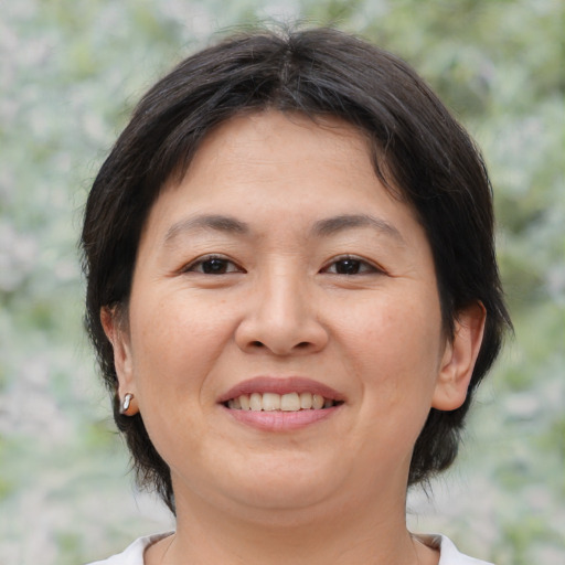 Joyful asian adult female with medium  brown hair and brown eyes