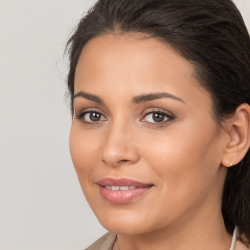 Joyful latino young-adult female with long  brown hair and brown eyes