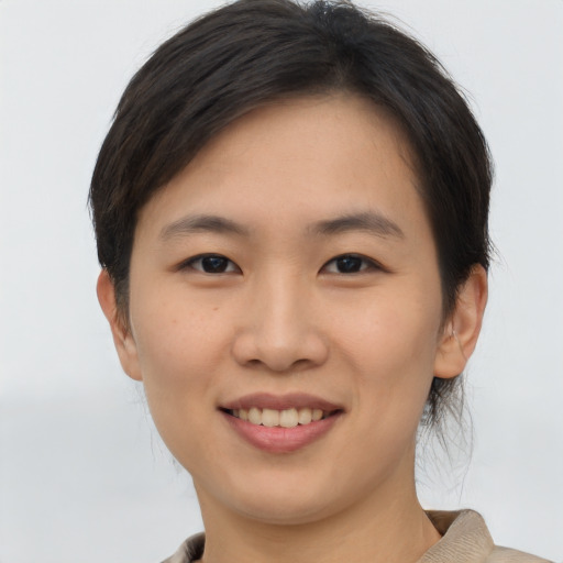 Joyful asian young-adult female with short  brown hair and brown eyes