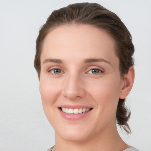 Joyful white young-adult female with medium  brown hair and grey eyes