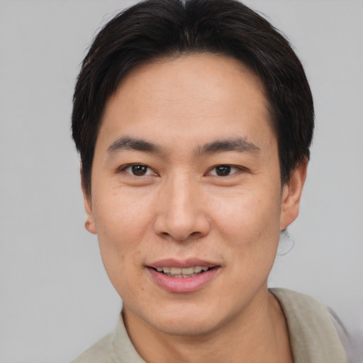 Joyful asian young-adult male with short  brown hair and brown eyes