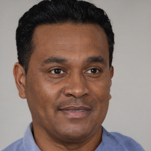 Joyful black adult male with short  brown hair and brown eyes