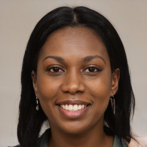 Joyful black young-adult female with long  black hair and brown eyes