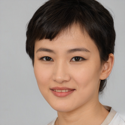 Joyful asian young-adult female with short  brown hair and brown eyes