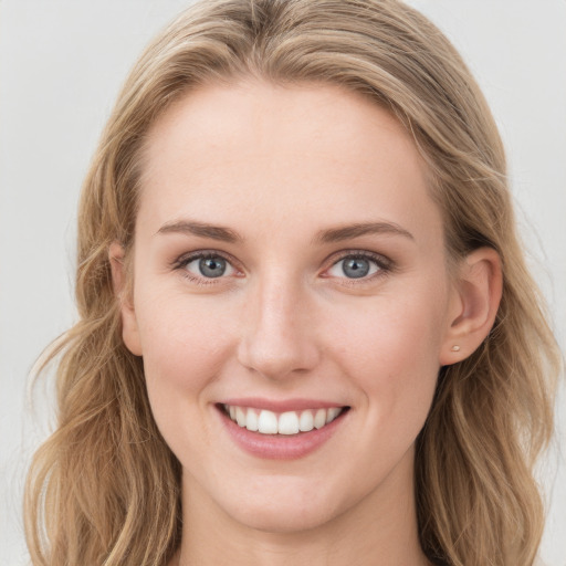 Joyful white young-adult female with long  brown hair and blue eyes