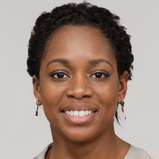 Joyful black young-adult female with short  black hair and brown eyes
