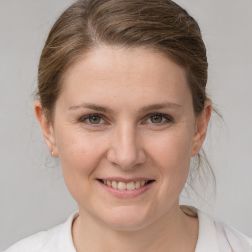 Joyful white young-adult female with medium  brown hair and grey eyes