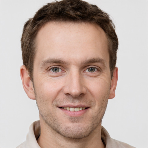 Joyful white adult male with short  brown hair and grey eyes