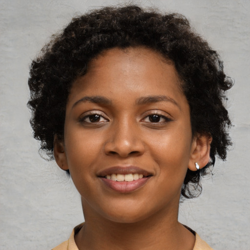Joyful black young-adult female with short  black hair and brown eyes