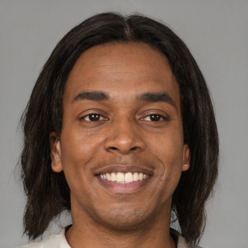 Joyful black adult male with medium  brown hair and brown eyes