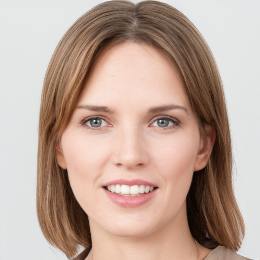 Joyful white young-adult female with medium  brown hair and grey eyes