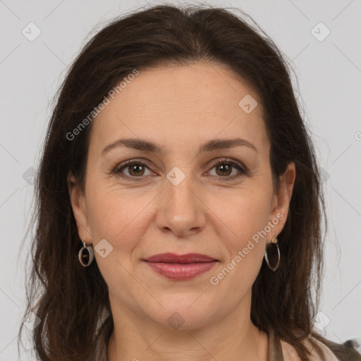 Joyful white adult female with long  brown hair and brown eyes