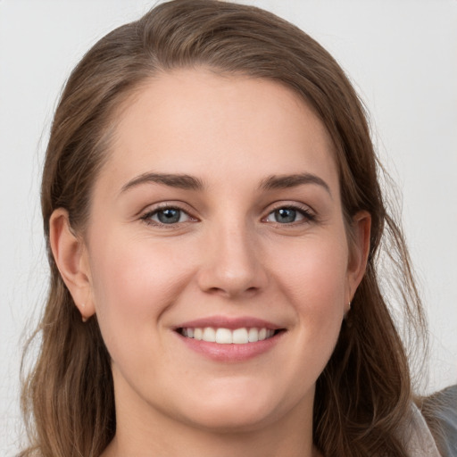 Joyful white young-adult female with long  brown hair and grey eyes