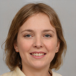 Joyful white young-adult female with medium  brown hair and blue eyes