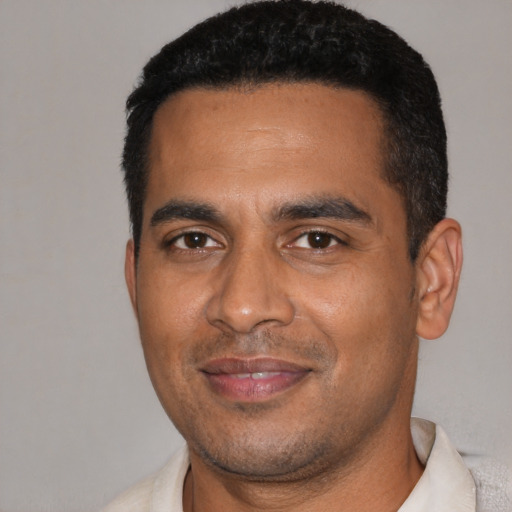 Joyful black young-adult male with short  black hair and brown eyes