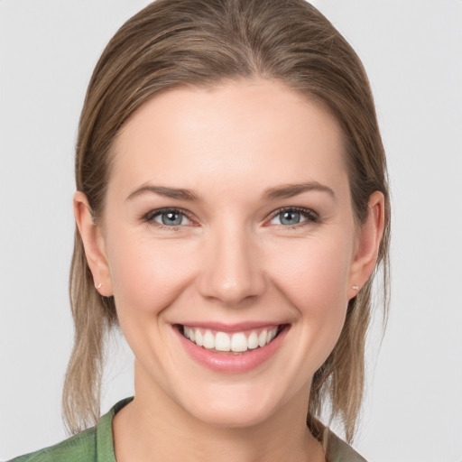 Joyful white young-adult female with medium  brown hair and grey eyes