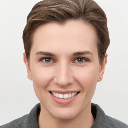 Joyful white young-adult female with short  brown hair and grey eyes