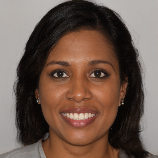 Joyful black young-adult female with medium  brown hair and brown eyes