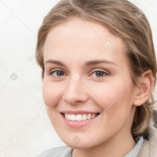 Joyful white young-adult female with medium  brown hair and blue eyes