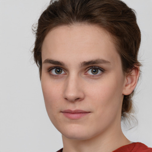 Joyful white young-adult female with medium  brown hair and green eyes