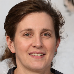 Joyful white adult female with medium  brown hair and grey eyes