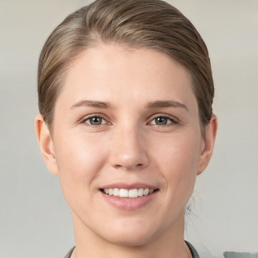 Joyful white young-adult female with short  brown hair and grey eyes