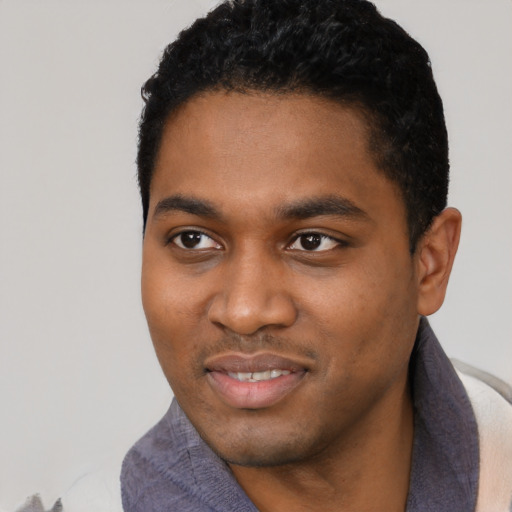 Joyful black young-adult male with short  black hair and brown eyes
