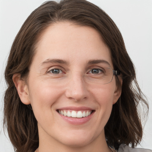 Joyful white young-adult female with medium  brown hair and grey eyes