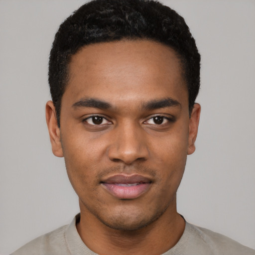 Joyful black young-adult male with short  black hair and brown eyes