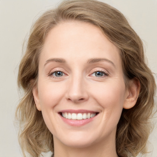 Joyful white young-adult female with medium  brown hair and blue eyes