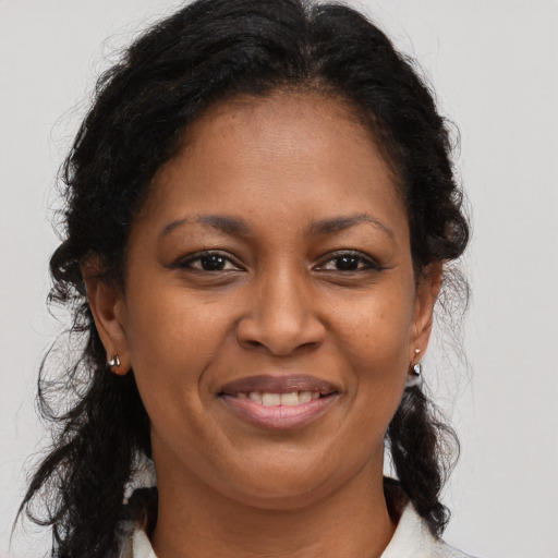Joyful latino adult female with medium  brown hair and brown eyes