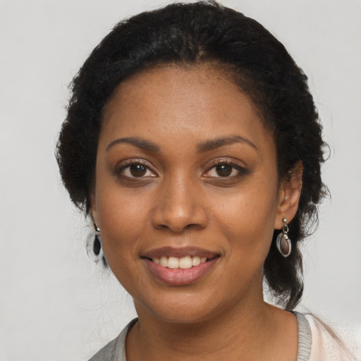 Joyful black young-adult female with medium  black hair and brown eyes